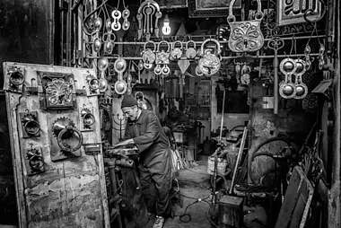 workshop and man working on a metal door component